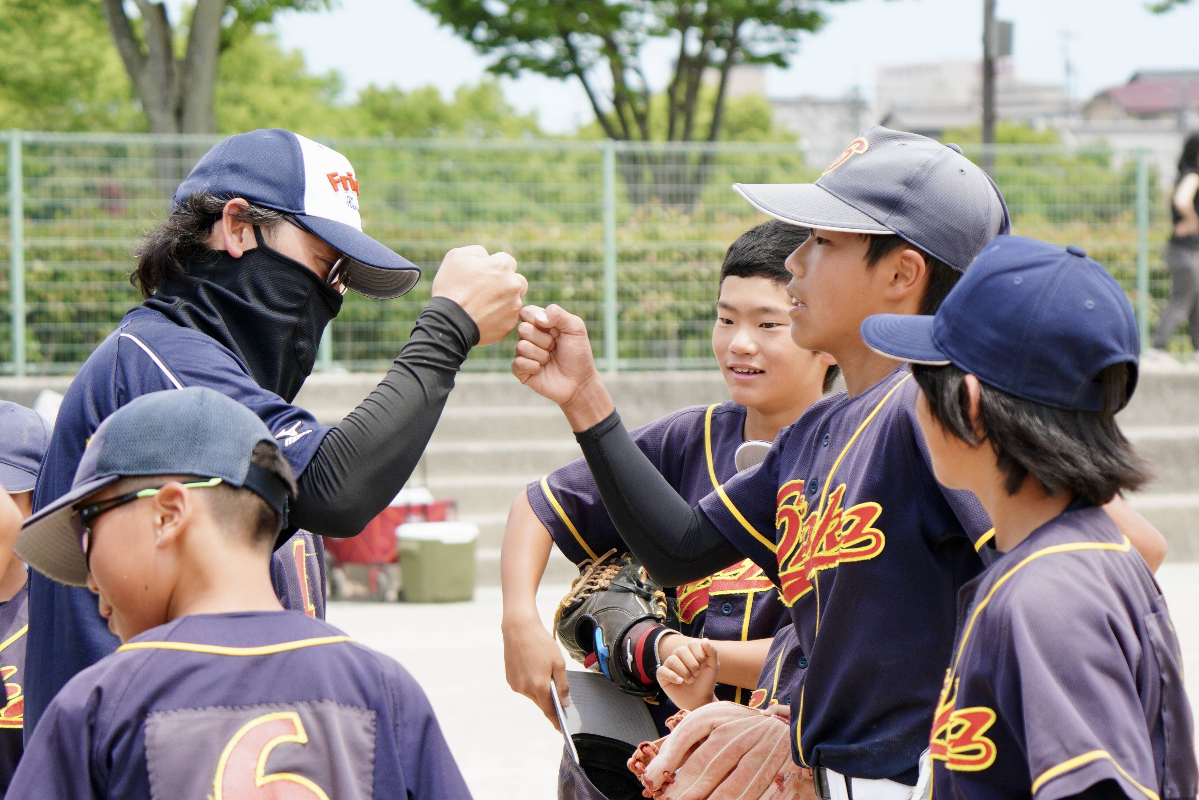 優秀賞 大高 ― 試合前に監督と選手が拳を合わせて士気を高める瞬間（第22回倉敷ケーブルテレビ杯ソフトボール大会フォトコンテスト受賞作品）