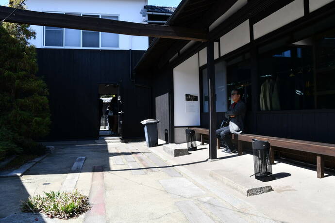 CAFÉ JAPAN BLUE GARDENの敷地内で休憩している真鍋さんの写真