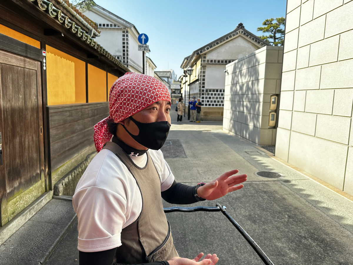 人力車を止めて美観地区の説明をする百田さんの写真