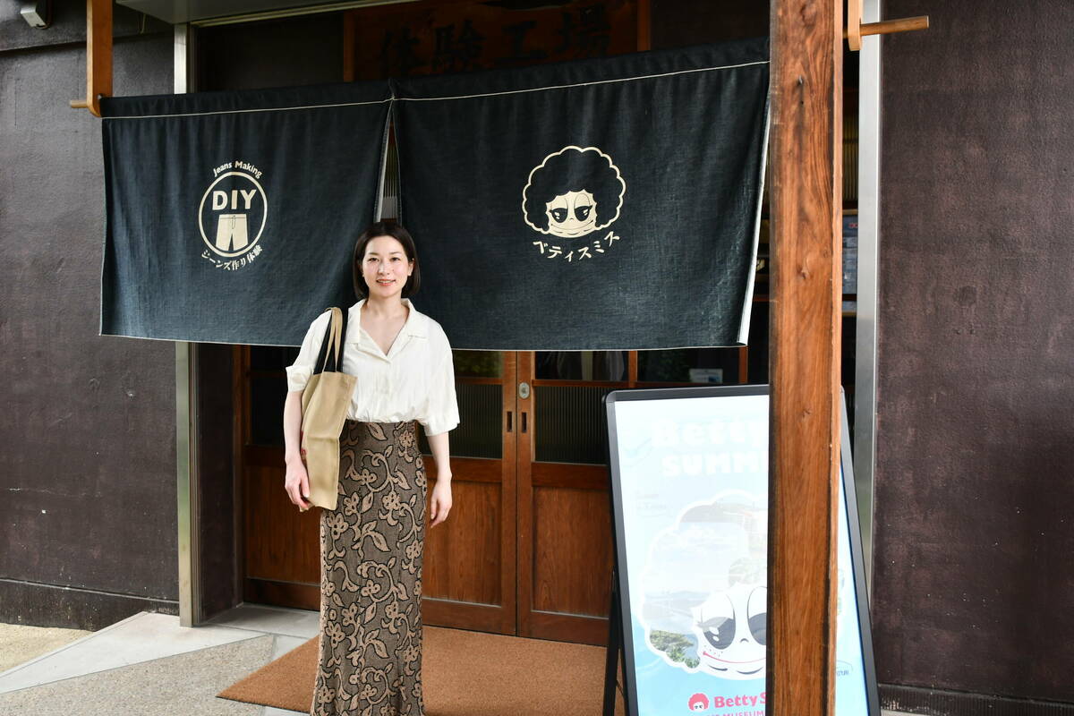 施設の入口で笑顔のNさん