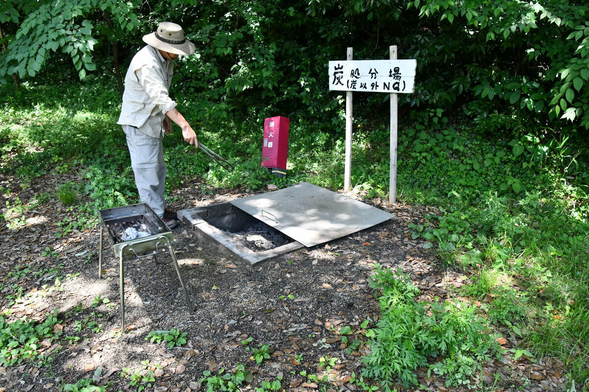 炭の捨て場で残りの炭を方付ける